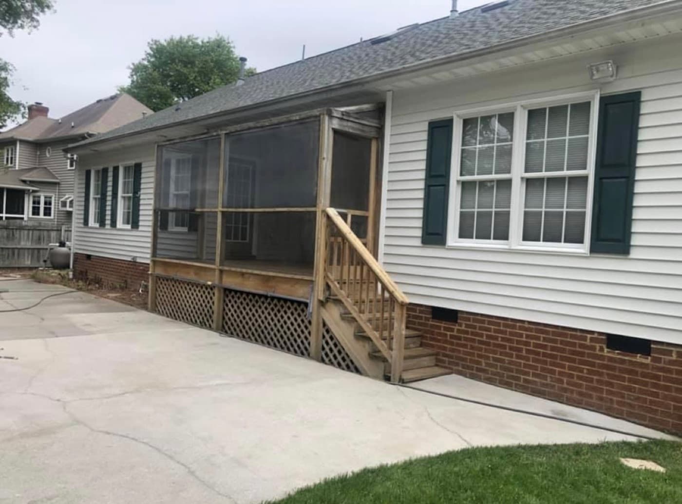 Screened porch before, with weathered railings and old lattice